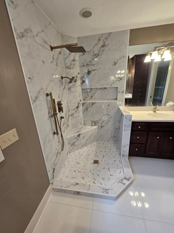 Marble-look tile walk-in shower with glass panel