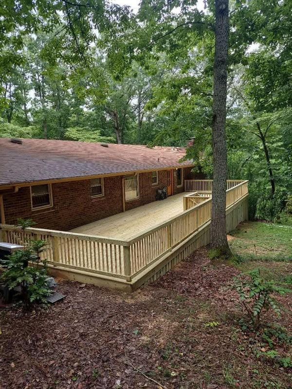 Wraparound deck added to a ranch home in the woods