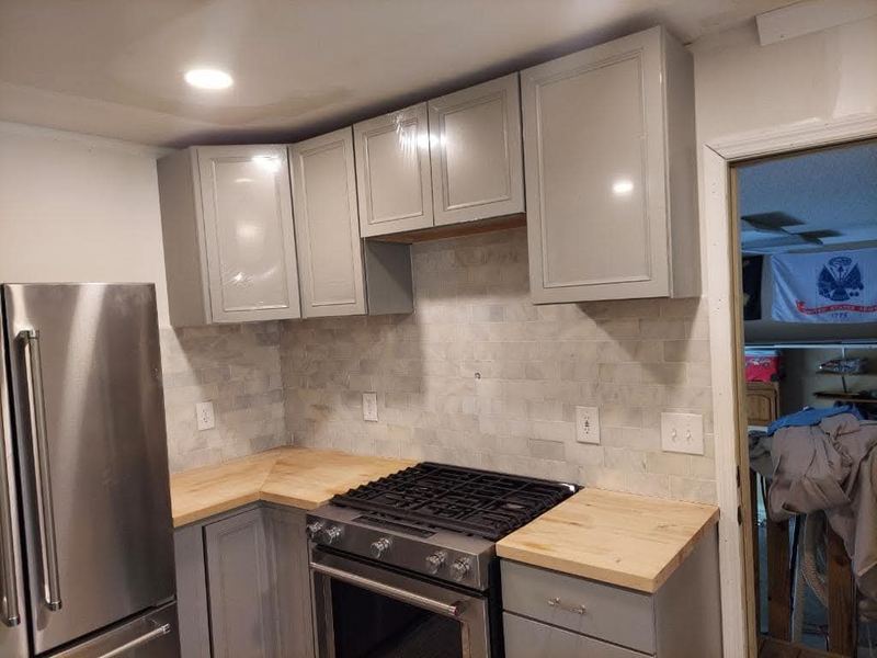 Kitchen with grey cabinets, gas range and butcher block counters