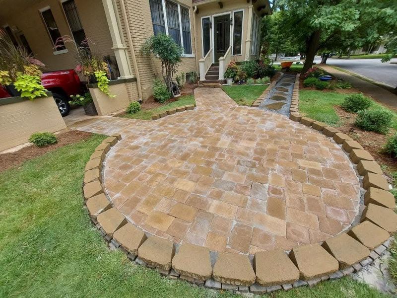 Circular paver patio with stone border in a front yard