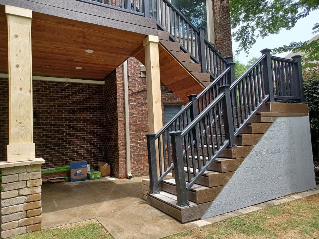 Finished under-deck patio with brick columns, beadboard ceiling and metal railing